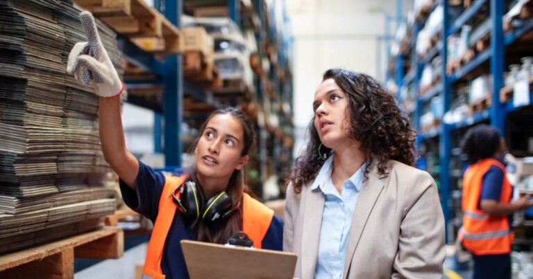 Warehouse manager with worker taking stock